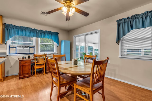 dining room with light wood finished floors, a ceiling fan, baseboards, and cooling unit