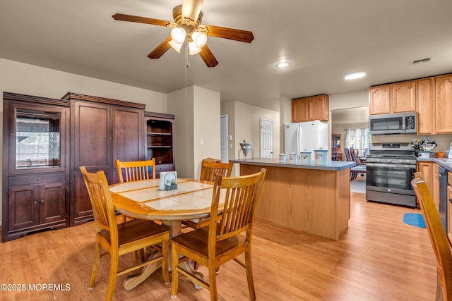 dining area featuring a ceiling fan and light wood finished floors