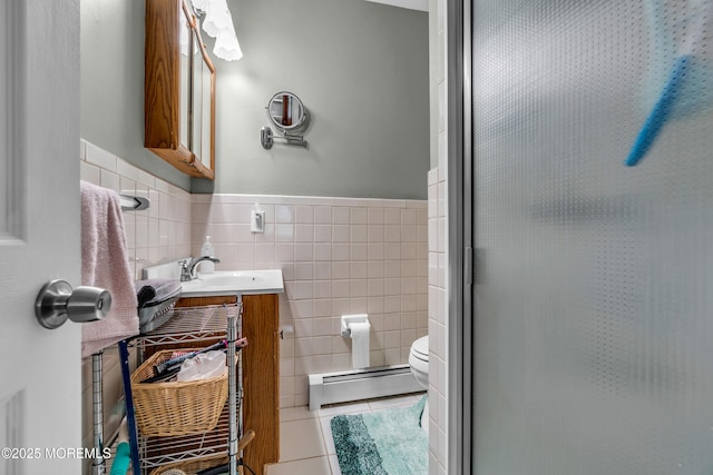 bathroom featuring a baseboard heating unit, tile walls, tile patterned floors, toilet, and a shower with shower door