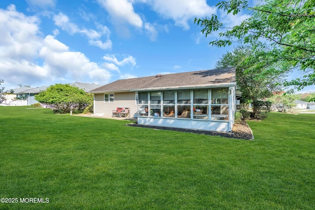 rear view of house with a yard, a patio, and a sunroom
