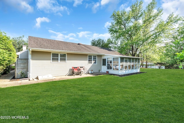 back of property with a sunroom, a yard, a patio area, and a shingled roof