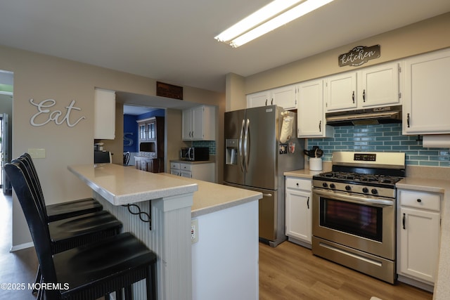 204 Stormy Rd, Manahawkin, NJ 08050 - kitchen with appliances with stainless steel finishes, under cabinet range hood, backsplash, light countertops, and white cabinets