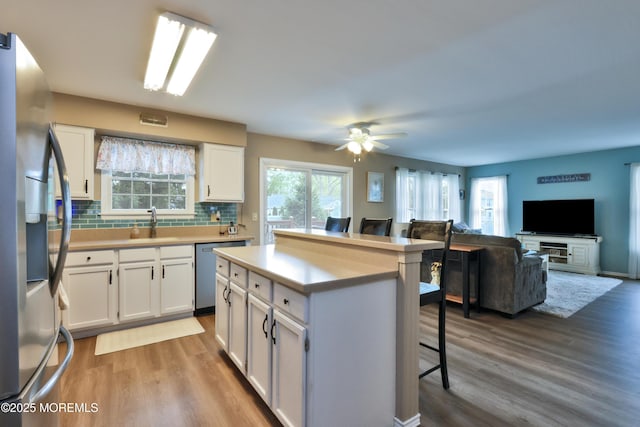 204 Stormy Rd, Manahawkin, NJ 08050 - kitchen with appliances with stainless steel finishes, a breakfast bar, wood finished floors, and white cabinets