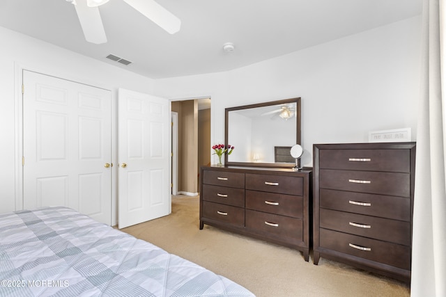 bedroom with light carpet, a ceiling fan, and a closet