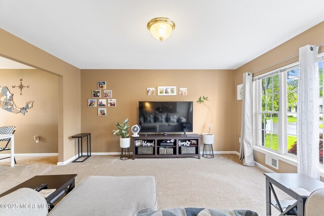 carpeted living area with baseboards