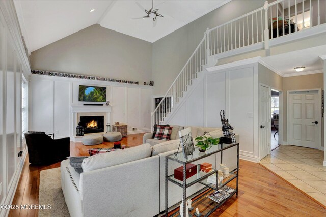 460 Christine Ct, Freehold, NJ 07728 - living room featuring stairs, light wood finished floors, high vaulted ceiling, and a lit fireplace