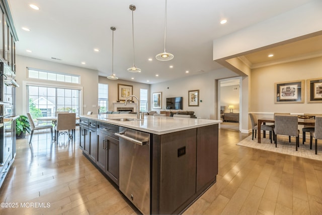9 Anvil Way, Freehold, NJ 07728 - kitchen featuring a sink, stainless steel dishwasher, open floor plan, light wood-type flooring, and dark brown cabinetry