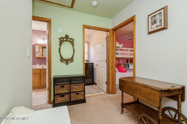 hall with light colored carpet and attic access