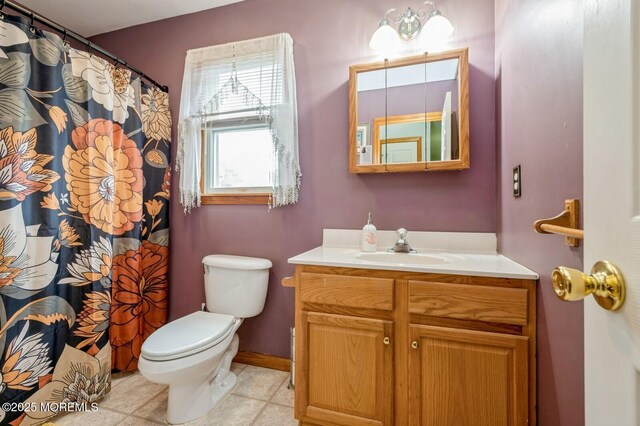 bathroom with toilet, vanity, and curtained shower
