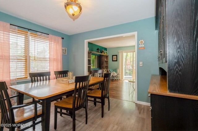 dining space featuring wood finished floors and baseboards