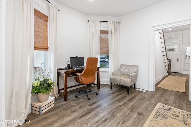 home office with wood finished floors, plenty of natural light, and baseboards