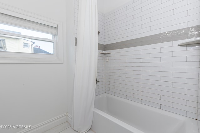 bathroom with baseboards and shower / tub combo