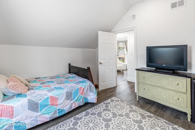 bedroom with vaulted ceiling and wood finished floors