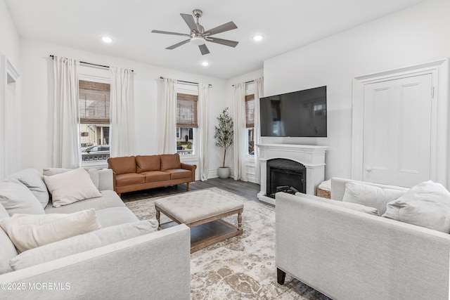 living area with a ceiling fan, light wood-type flooring, a fireplace, and recessed lighting