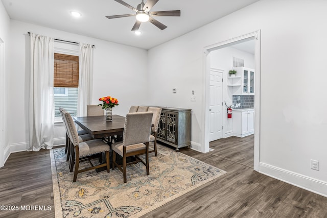 dining space featuring dark wood-style floors, a ceiling fan, baseboards, and recessed lighting