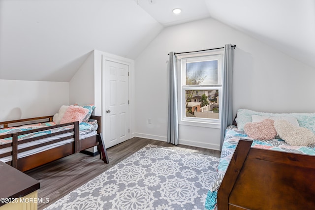 bedroom featuring wood finished floors, vaulted ceiling, and baseboards