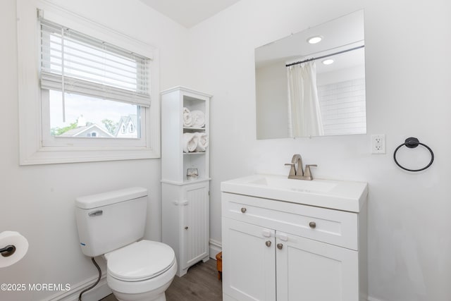 bathroom featuring toilet, vanity, and wood finished floors