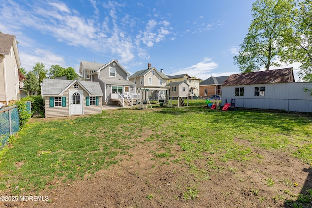 rear view of property with a playground, a residential view, and an outdoor structure