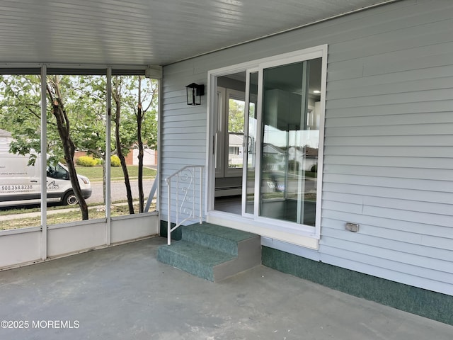 unfurnished sunroom featuring entry steps and a baseboard radiator