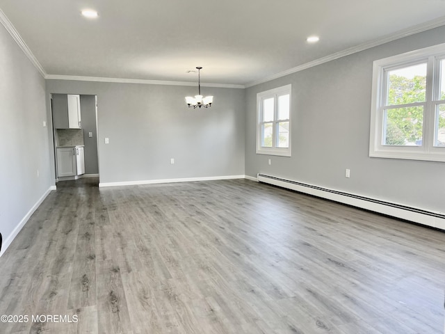unfurnished room with a chandelier, healthy amount of natural light, a baseboard radiator, wood finished floors, and ornamental molding