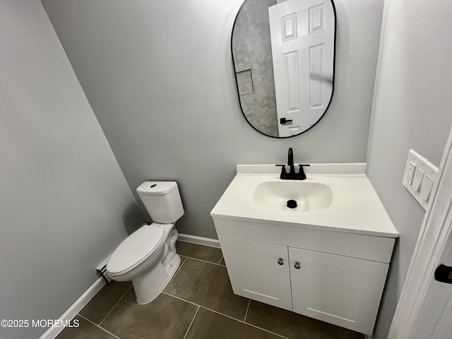 bathroom featuring tile patterned flooring, vanity, toilet, and baseboards