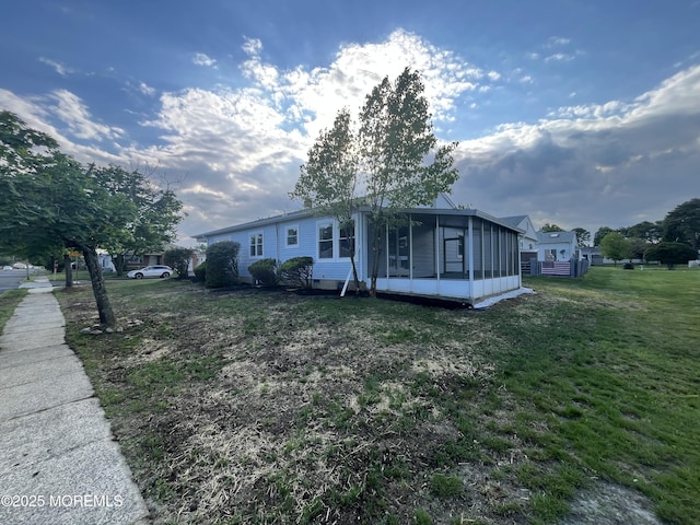 view of front of house featuring a sunroom and a front yard