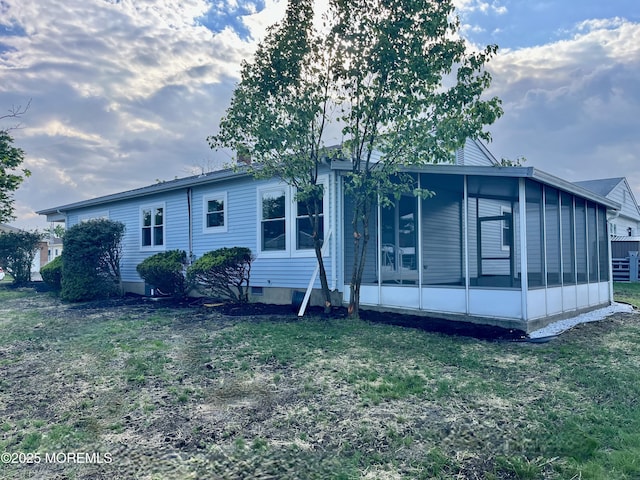 manufactured / mobile home featuring a sunroom and a front yard