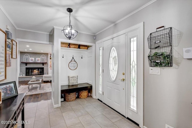 733 Colts Neck Rd, Freehold, NJ 07728 - entrance foyer featuring a chandelier, healthy amount of natural light, a brick fireplace, light tile patterned flooring, and crown molding