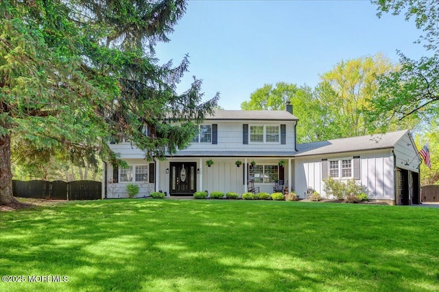 733 Colts Neck Rd, Freehold, NJ 07728 - view of front facade with board and batten siding, a chimney, a garage, and covered porch