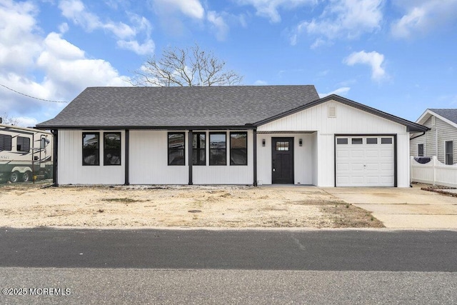 ranch-style house with roof with shingles, concrete driveway, and an attached garage