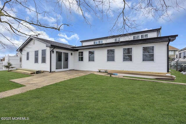 back of house featuring fence, a patio, and a lawn