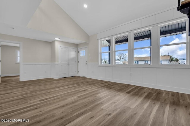 unfurnished living room with wood finished floors, wainscoting, and recessed lighting