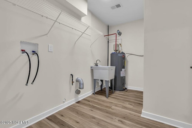 laundry area with washer hookup, laundry area, hookup for a gas dryer, water heater, and baseboards