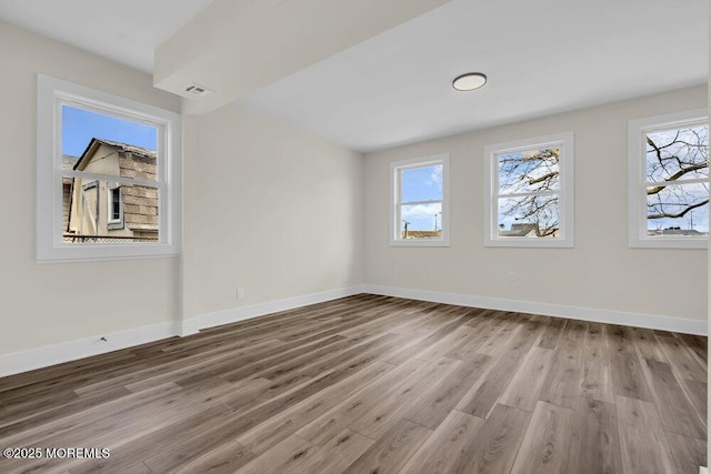 interior space featuring visible vents, light wood-style flooring, and baseboards