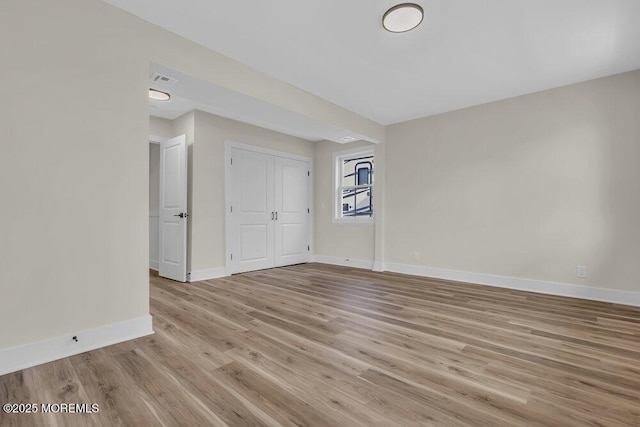 empty room featuring light wood-style floors and baseboards