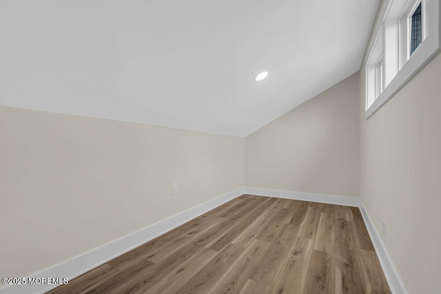 additional living space with lofted ceiling, baseboards, light wood-type flooring, and recessed lighting