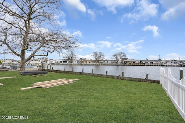 view of yard featuring fence, a water view, and a residential view