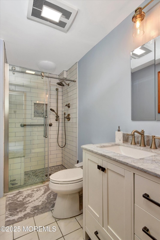 bathroom with toilet, vanity, visible vents, tile patterned flooring, and a shower stall