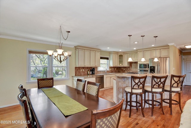 dining room featuring light wood finished floors, a notable chandelier, baseboards, ornamental molding, and recessed lighting