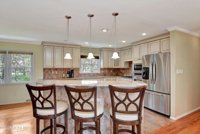 kitchen featuring a sink, stainless steel appliances, cream cabinetry, and baseboards