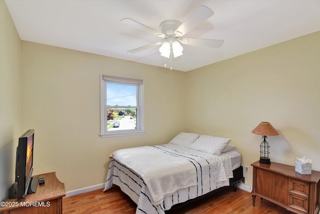 bedroom featuring baseboards, a ceiling fan, and wood finished floors