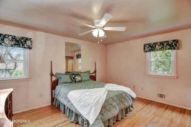 bedroom featuring multiple windows, visible vents, and light wood-style flooring
