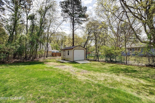 view of yard with an outbuilding, fence, and a detached garage