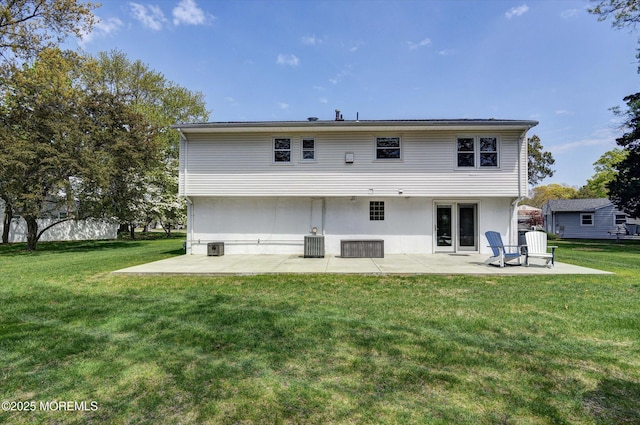 rear view of property with a patio, a lawn, and central AC