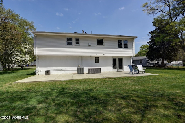 rear view of property featuring central AC unit, a lawn, and a patio
