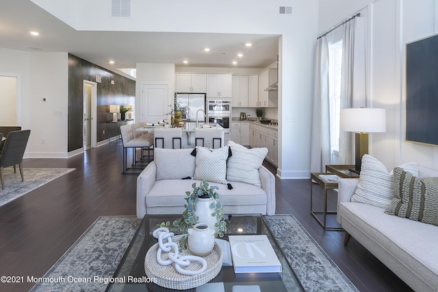 living area with baseboards, dark wood-style floors, visible vents, and recessed lighting