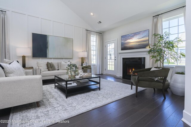 living area featuring a lit fireplace, recessed lighting, visible vents, and dark wood finished floors