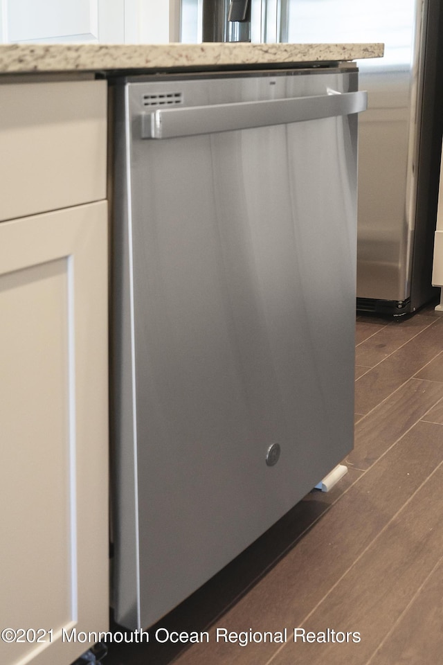 details with dishwasher, light countertops, and dark wood-style floors