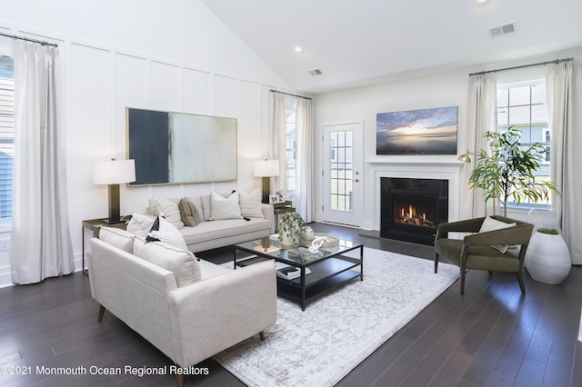 living area featuring a glass covered fireplace, dark wood-type flooring, visible vents, and recessed lighting