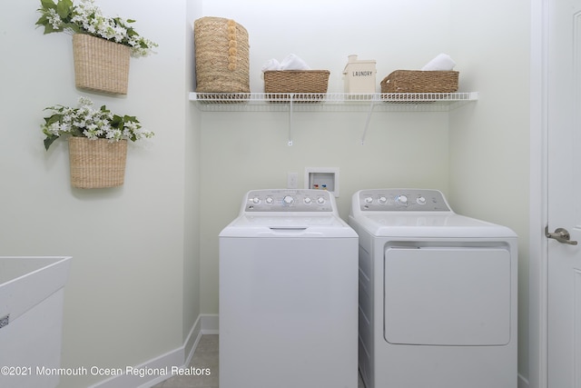 washroom featuring laundry area, baseboards, and separate washer and dryer